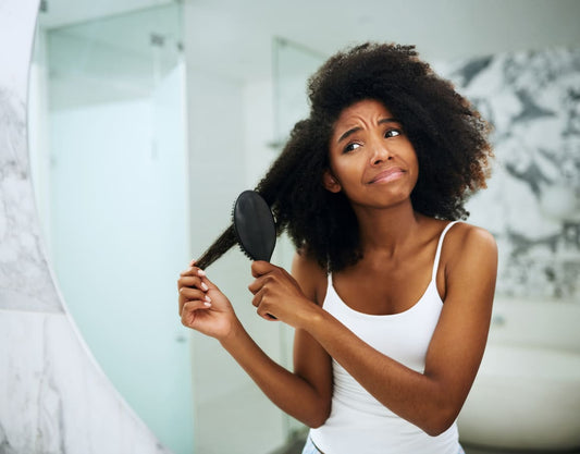 woman brushing dry damaged hair